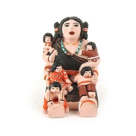 Native American Style Storyteller Figurine: A Native American style storyteller figurine. This figurine depicts a mother-like figure at the center with five small children clinging to her body. It is made of colorful painted ceramic. Unmarked.