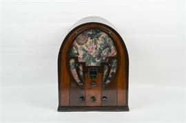 Vintage Philco Radio: A vintage Philco radio. This radio is composed of a stained and lacquered wood with four dials. The speaker covers are decorated with a colorful floral design. The front is marked Philco and the interior is marked Philco Radio Chassis Type 60.