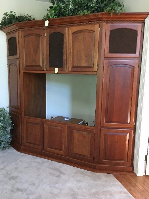 Custom built Cherry entertainment center which extends 36" out from each corner. There is shelving behind upper doors for stereo and components. Can hold up to 55" TV