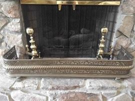 Antique English brass fire fender and newer brass andirons. 