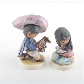 Goebel "The Children of DeGrazia" Figurines: A pair of porcelain figurines from The Children of DeGrazia collection by Goebel. This pair offers My First Horse and The White Dove. Both have decals on the sides of their bases with their titles, and are marked to their undersides “Goebel”.