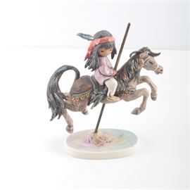 Goebel The Children of DeGrazia 'Merry Little Indian' Porcelain Figurine: A limited production figurine from the company Goebel. This piece is entitled Little Indian and was designed by painter and sculptor Ted Degrazia with this particular edition made to celebrate Degrazia’s tenth anniversary in designing collectibles. The maker’s and edition marks are present on the underside of the figurine with this piece being number 1,003 of 2,005 manufactured.