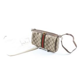 Vintage Gucci Signature Canvas Crossbody: A vintage crossbody bag by Gucci. This purse showcases the signature GG canvas, accented by the classic red and green striped webbing. Brown leather finishes the top trim, piping and adjustable crossbody strap. The zippered top opens to a tan suede lining and a branded hang tag with 84-02-018 to the underside. A white “Gucci” dust bag accompanies the listing.