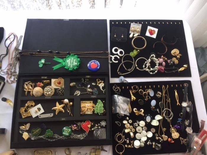 Many jewelry items including necklaces, pins, bracelets, watches and earrings