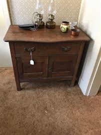 Nice size oak commode.  Pair of wall hanging liquid fuel lamps (fonts are newer, chimneys and hangers older).  