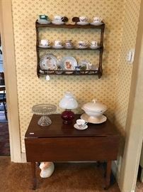 Small cherry dropleaf table (has been restored with repairs).  Cup and saucer collection; Fostoria dessert server, ruby red base Fenton style lamp.