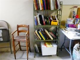 bakers rack filled with cook books and an antique highchair 