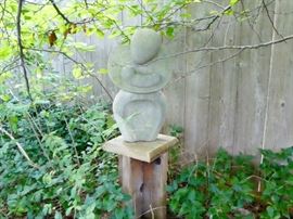 cement statue of woman holding child. yard art