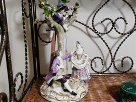 Meissen figurine depicting an 18th century european man and woman under an apple tree a ladder is leaning against the tree and a small child is in the tree dropping apples the woman is gathering them in her apron and a basket at her feet German late 19 th century hard-paste porcelain, polychrome detail  Meissen blue crossed swords mark plus incised numbers 57 and 2229 under glaze on reverse side.