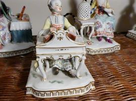 figurine depicting the "sense of Touch"woman seated at and playing a harpsichord feeling the music as she touches the keyboard an open book of music rests on top of the harpsichord . Meissen crossed swords plus incised numbers E1, 29 and 43 under glaze on reverse side.