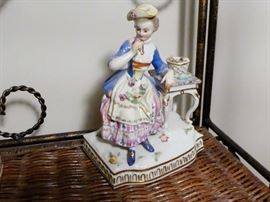 "Sense of Smell"  Meissen figurine holding flowers  and wearing a hat on her head. Meissen crossed swords mark plus incised numbers E5 and 104 under glaze on reverse side.  excellent condition all