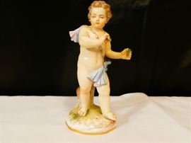 Meissen figurine representing a standing cherub holding a flower in his hand a blue drape is around his shoulders down around the lower part of his torso german late 19th century  hard-paste porcelain polychrome detailed.  5 inches high good condition 