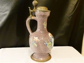 Glazed earthenware ewer (or flagon)with manganese -purple decoration overall with an inset coat of arms and flower on the front  Central or northern european mid 18th century pewter mounted lid and foot rim.