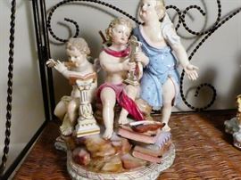 Meissen figurine depicting three cherubs one playing harp, one playing flute and one singing
