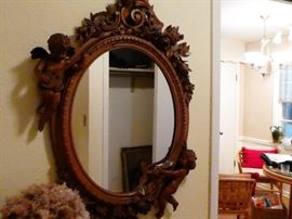 Oval wall mirror- Italian  wood frame heavily carved with acanthus leaves scroll work, and two cherubs one playing a mandolin  and one holding a banner this is also a signed  piece  banner says Gli Impiegati Logo Tegretirio 