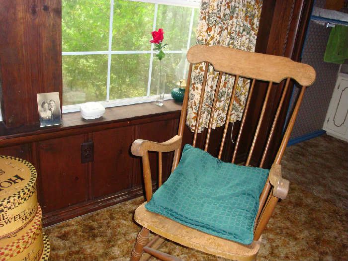 Wooden rocker with pillow. Antique photo in the background.