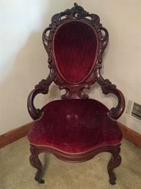 Carved armchair, with red velvet upholstery. Roxanne left the red light on again.