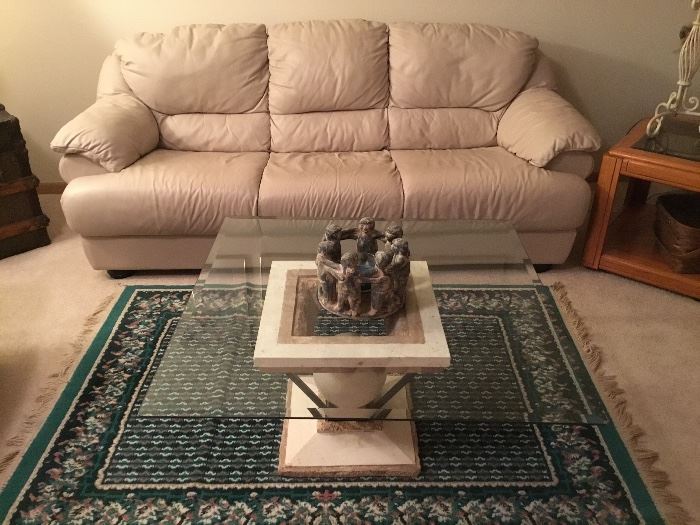 Ivory leather sofa, contemporary glass top coffee table and area rug