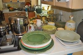 Kitchen items including Revere Ware, Farberware, plates, platters, baking dishes, serving bowls, goblets, sugar/creamer sets, pitchers, mixing bowls