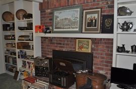 Baskets, books, wooden antique cheese boxes, brass, vintage Minolta camera, Kodak No. 2 folding Brownie Autographic antique camera, travel guides, Akai 4 channel surround stereo tape deck GX 280 DSS, Akai stereo headphones ASE-9S, antique copper boiler with lid, vintage shoe ice skates, vintage ice skates, albums, framed artwork 
