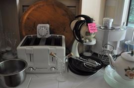 Stainless steel bowls, toaster, cutting board, antique mixer on stand, tea pot, dishes, food processor, wine glasses