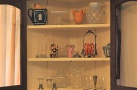 Wedgwood English blue/white Jasperware pitcher 6.5 inches tall early 20th, dolphin American compote opalescent top with clear base circa 1870-1880, art glass vase as seen, opalescent American coin spot water pitcher with crimped rim and clear applied handle circa 1880, crystal bud vases, newer salt/pepper shakers, what would an estate sale be without a Hummel figurine? (Mountaineer) TMK-4, EAPG bowl, Booth’s English porcelain vase floral decorated 5.5 inches tall late 19th to early 20th century, Cranberry American molded glass pickle jar hand decorated in silver plated stand with cover and tongs late 19th century as seen, German Jasperware green and white wall pocket, small crystal bud vases with sterling bases, apothecary jar with ground glass lid, glass vase, fluted edging at top, five star cut clear engraved glass tumblers (4)