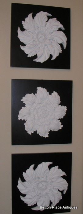 Three separate boards with plaster flower décor..