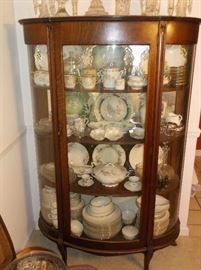Oak bow front china cabinet filled w/fine china