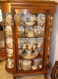  Bow front oak china cabinet w/carved lion heads filled w/fine china 