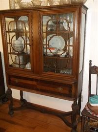 Walnut china cabinet with inlaid drawers and fret work on doors