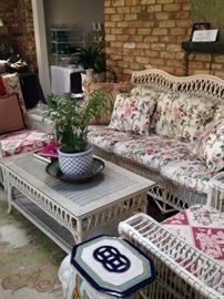 White wicker sofa, coffee table, chairs, and end table