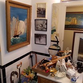 View of framed photos and artwork in the bathroom.  Top of the 3 photos is an enlargement of the snapshot of Chet Luders sitting on the wing of a Flying Tiger.