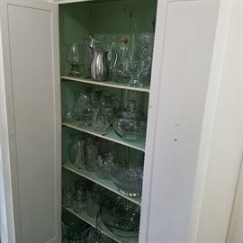 Cabinet full of glass vases, bowls, storage jars...