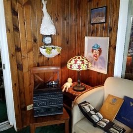 Stereo receiver, Stained glass lamp on wicker table, Original painting of clown, decorative items