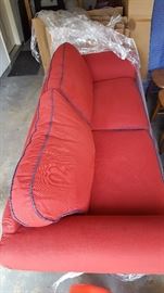 red couch, navy blue piping on cushions, wood feet and detailing