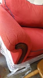 red couch, navy blue piping on cushions, wood feet and detailing