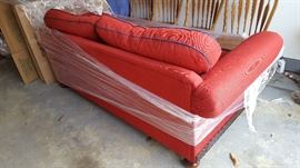 red couch, navy blue piping on cushions, wood feet and detailing