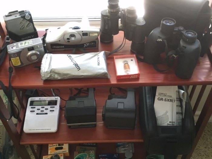3 generations of Polaroid cameras: Sun 600 LMS, One Step & Joycam; JVC Compact VHS camcorder in bag; 7.35 Optimatic field binoculars by Optex (NOTE:  Nikon binoculars with case, Walkman & Watchman have been pulled from the sale due to broken lens on the first and battery corrosion on the others).