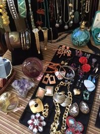 Assortment of jewelry, crystal balls, perfume atomizer, watches, piece of raw amethyst