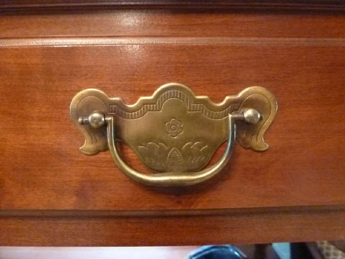 Detail on the drawer pull of the side table of the dining room set.