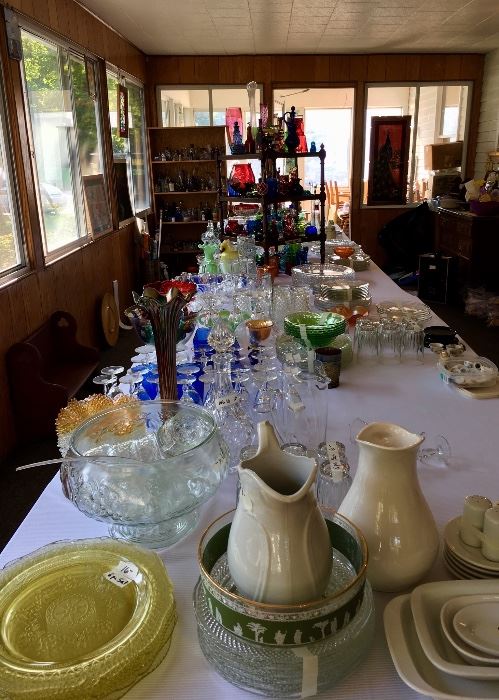 A room long view displaying the variety of stoneware, punch bowl sets and cups, specialty etched glassware, glass, glass, glass..including a bottle collection.