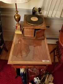 Antique Victrola player with vinyl records, wool middle eastern wall hangings, end tables, table lamps