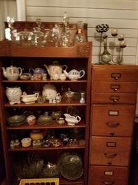 Bookcase, wooden file cabinets, salt & pepper shakers, lamp shades, china tea sets, cruets, vintage vases, trio candle stick