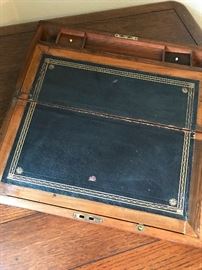 When the desk is folded out, it is angled and includes 2 small compartments for holding items and a place to store pens.