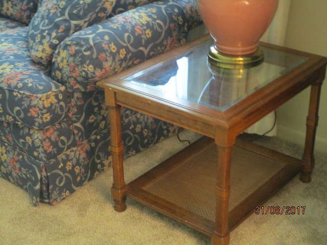One of two wood and beveled glass end tables