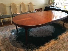 Henredon solid cherry dining table, oval with three leaves atop vintage Karastan Green Kirman rug.