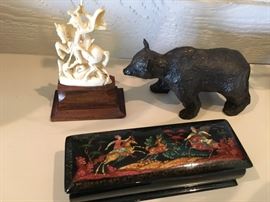Clockwise from upper left: St George slaying dragon bone sculpture, black bear sculpture by Betty Souder and hand painted black lacquer box from Russia