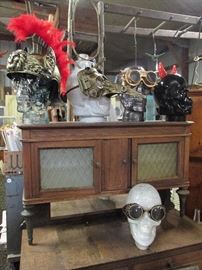 Steampunk goggles, masks, gladiator helmet and horn Halloween accessories on recycled glass skull sculptures