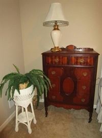 Antique chest of drawers, lamp, wicker plant stand
