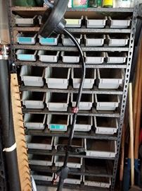 Storage bins and metal rack for garage or workshop organization.